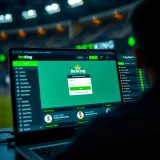Mobile phone displaying BetKing Shop Mobile app interface with sports betting options